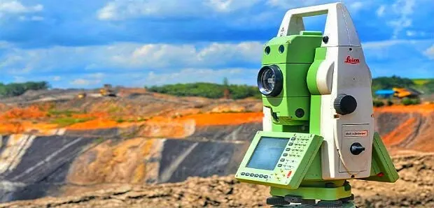 Tachimetr na statywie podczas pomiarów geodezyjnych na placu budowy